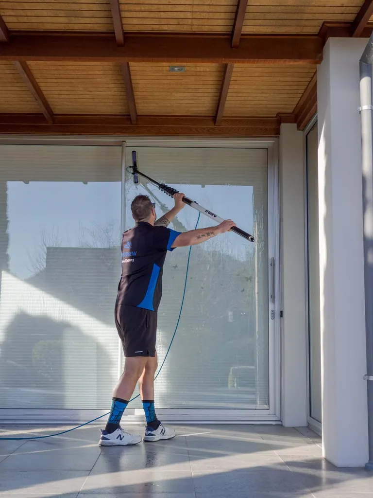 Mike cleaning full-height glass on a Wanaka building