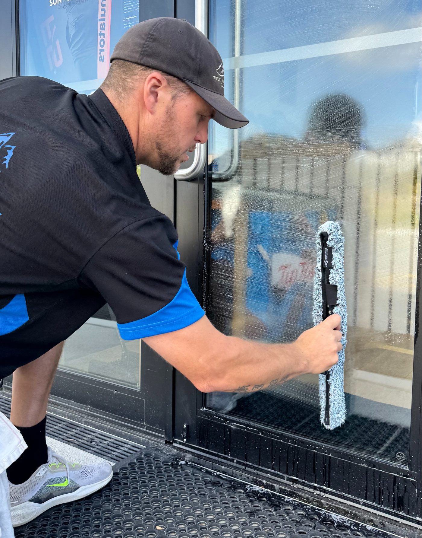Mike cleaning commercial glass with a squeegee in Wanaka